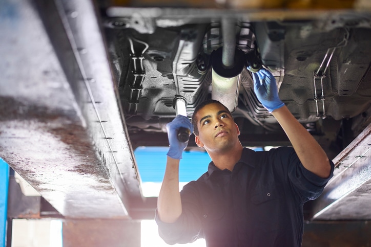 mechanic working under a car in a garage 