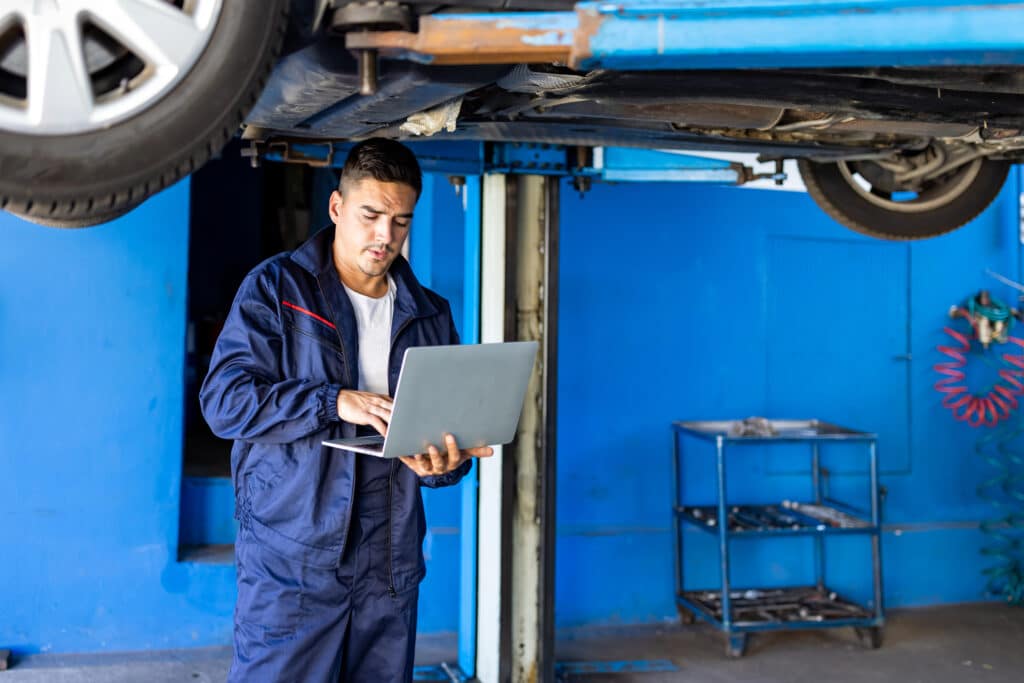 Portrait of a mechanic repairing a lifted car