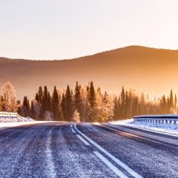 La route dans les montagnes d'hiver en arrière-plan