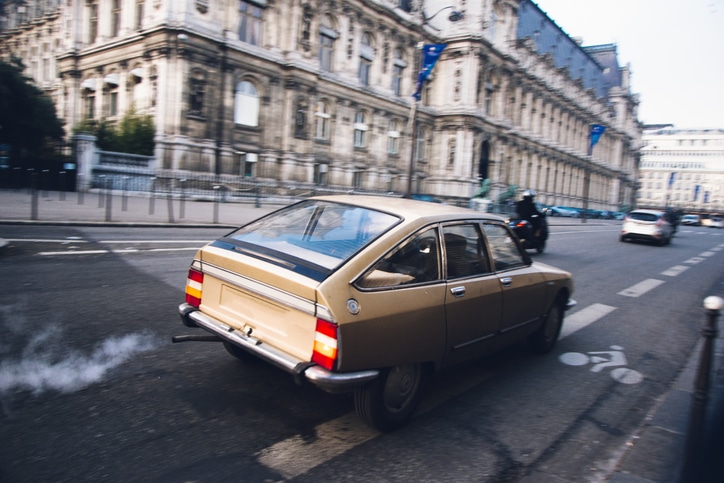 Old car driving and polluting Paris