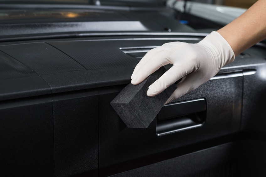 washing interior of car with black sponge