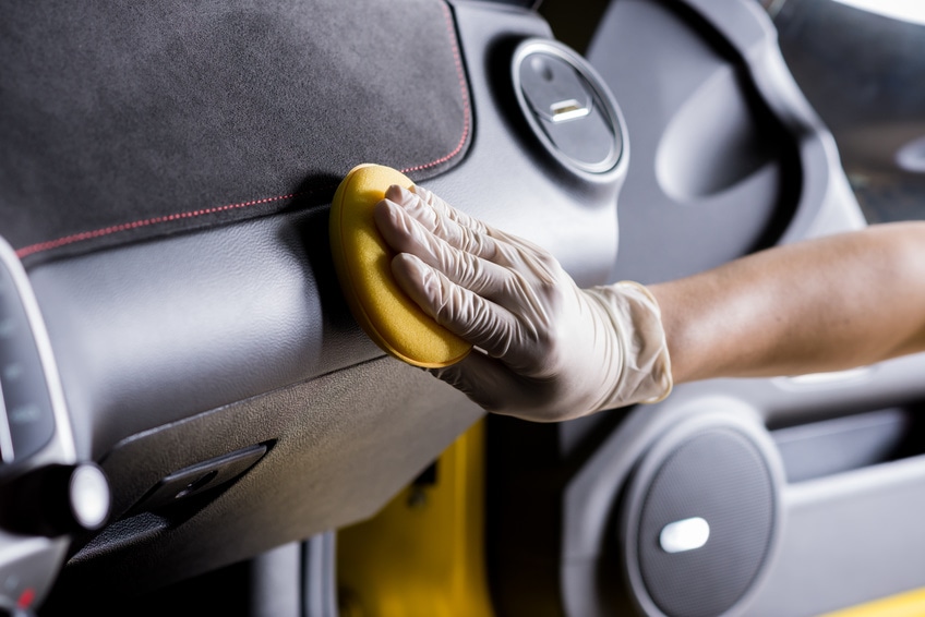 Using sponge on car headboard to clean scratches