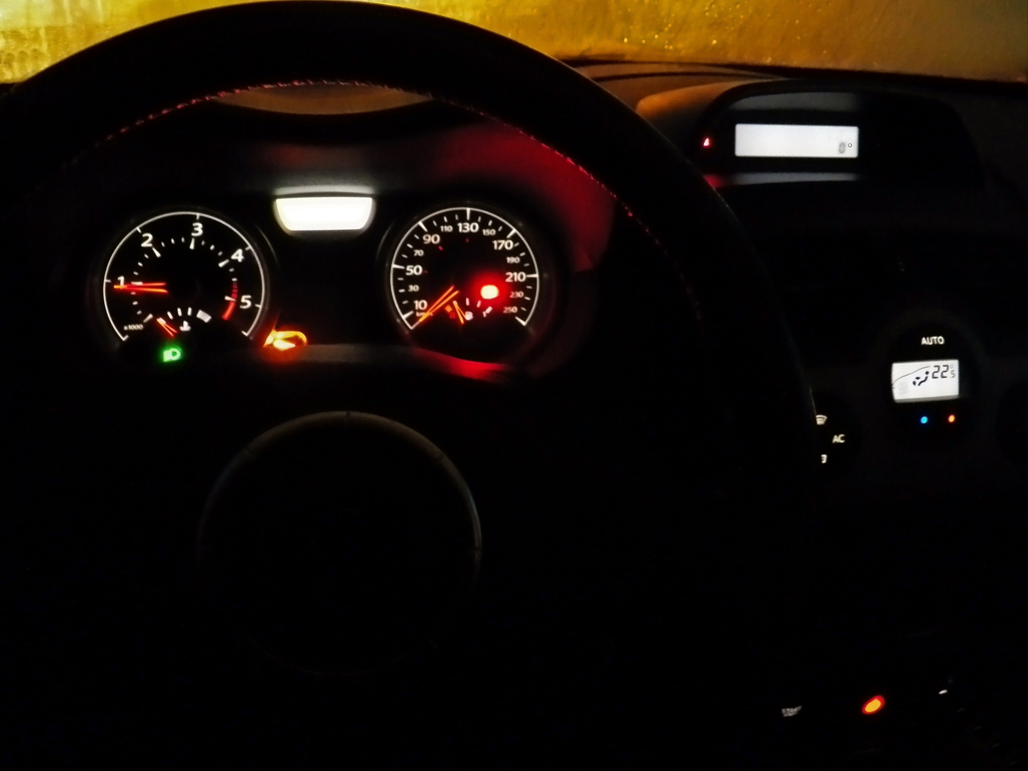 Night illuminated dashboard CLOSE-UP A black interior MOTOR VEHICLE with lighting equipment, red lines, with indicators and some measure equipment -- format 4x3 Close up on the steering wheel. ZERO