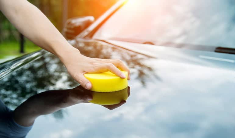 Essuyer une voiture avec une éponge