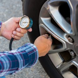 Man Checking Tyre Pressure While Maintaining Tyres