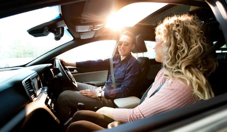 Couple talking while sitting in car during test drive