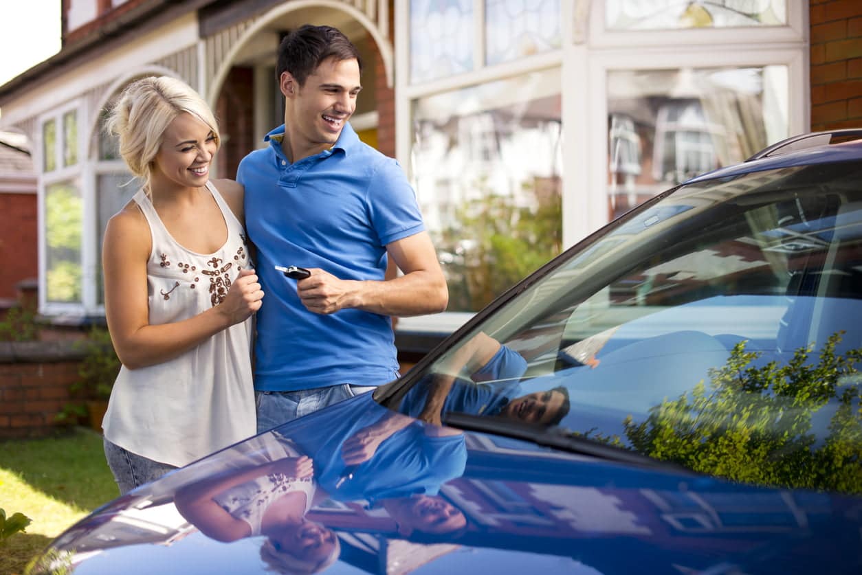 young couple with their new car