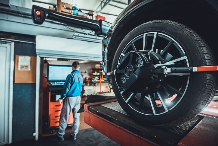 mechanic aligning car wheels