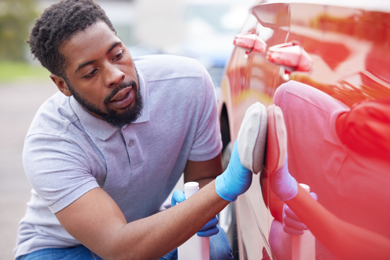 man polishing his car