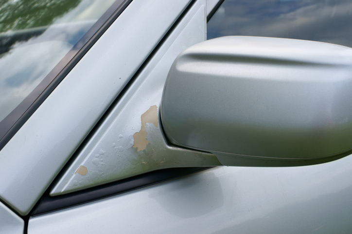 The car, peeling paint at rear-view mirror