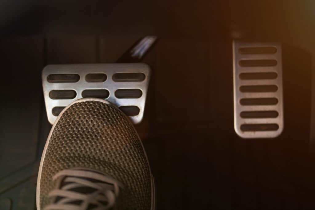 Pressing break car pedal with shoe close up view