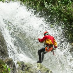 A person climbing down a waterfall