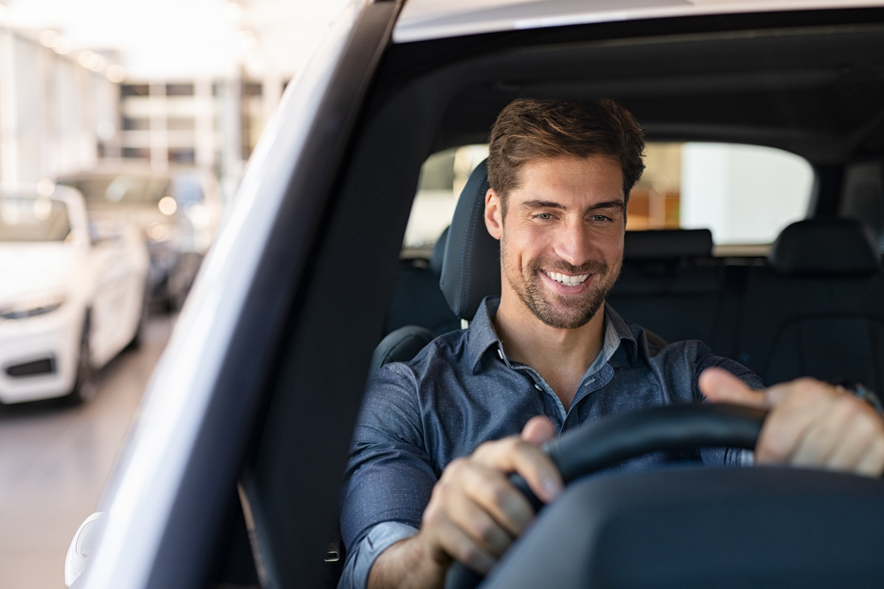 man smiling driving his car