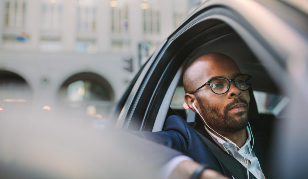 businessman listening to podcast in his car