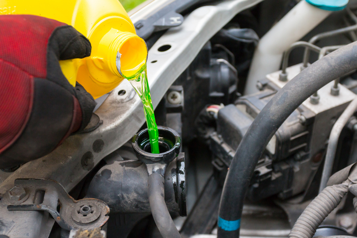 pouring engine coolant into engine