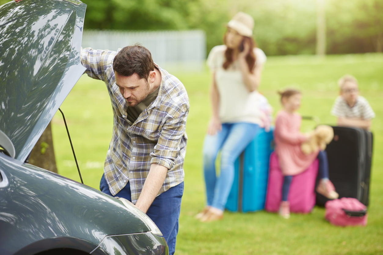 A Father assessing the family car after a break down 