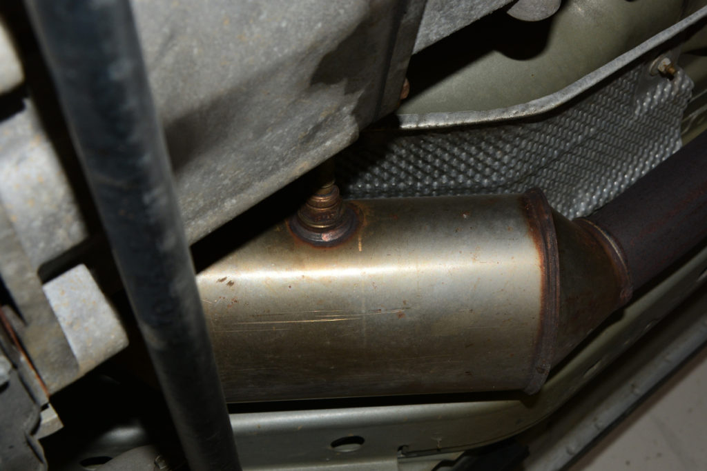 Selective focus on Oxygen Sensor mounted directly to a Catalytic Converter on the underside of a automobile. Catalytic Converters contain precious metals and are a target for theft.