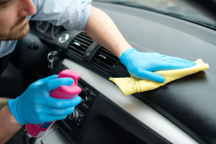 Man cleaning his car interiors and dashboard