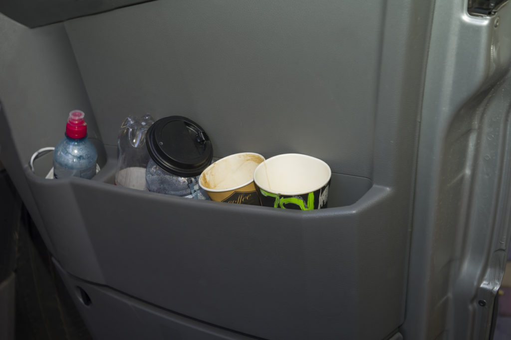 Plastic bottles and disposable cups in a car door