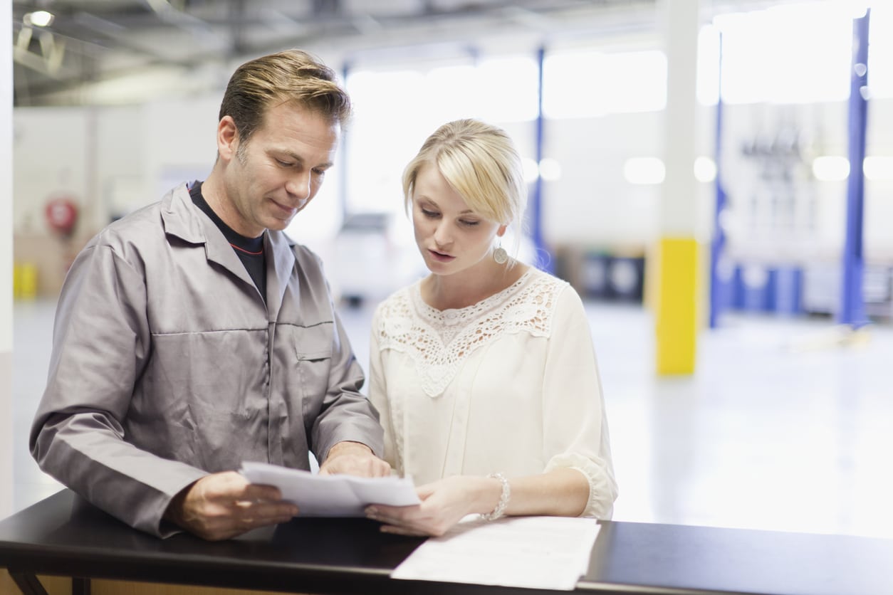 Mechanic talking to customer in garage