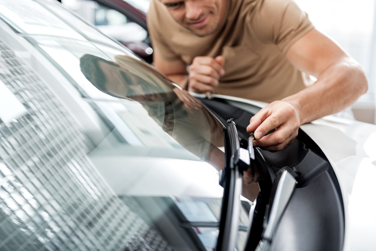Outgoing man straightening wipers in automobile. He standing near it. Adoration concept