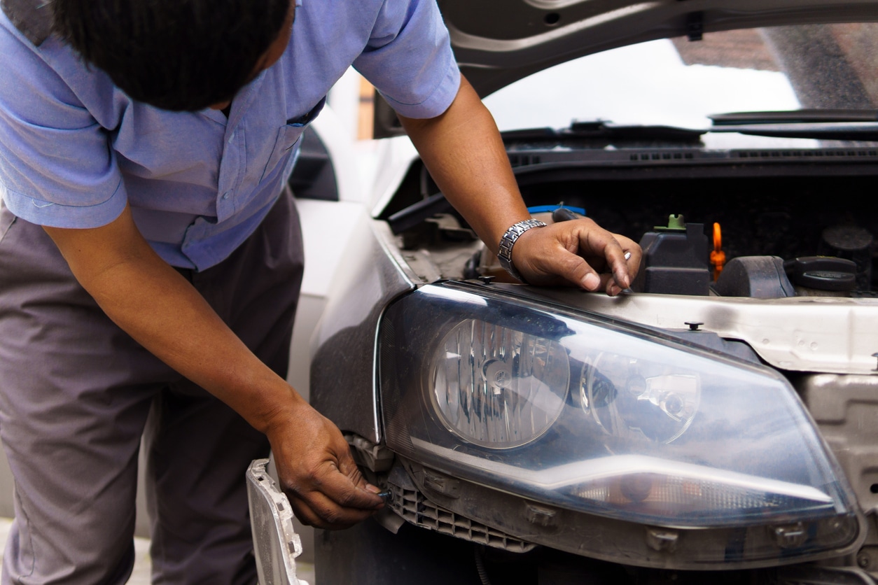 Auto mechanic upgrading halogen headlights to led technology, improving vehicle lighting