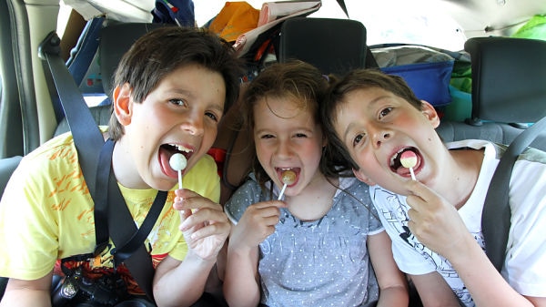 three brothers while traveling by car while eating a candy